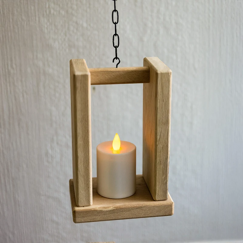 Holzstele mit hängender Laterne